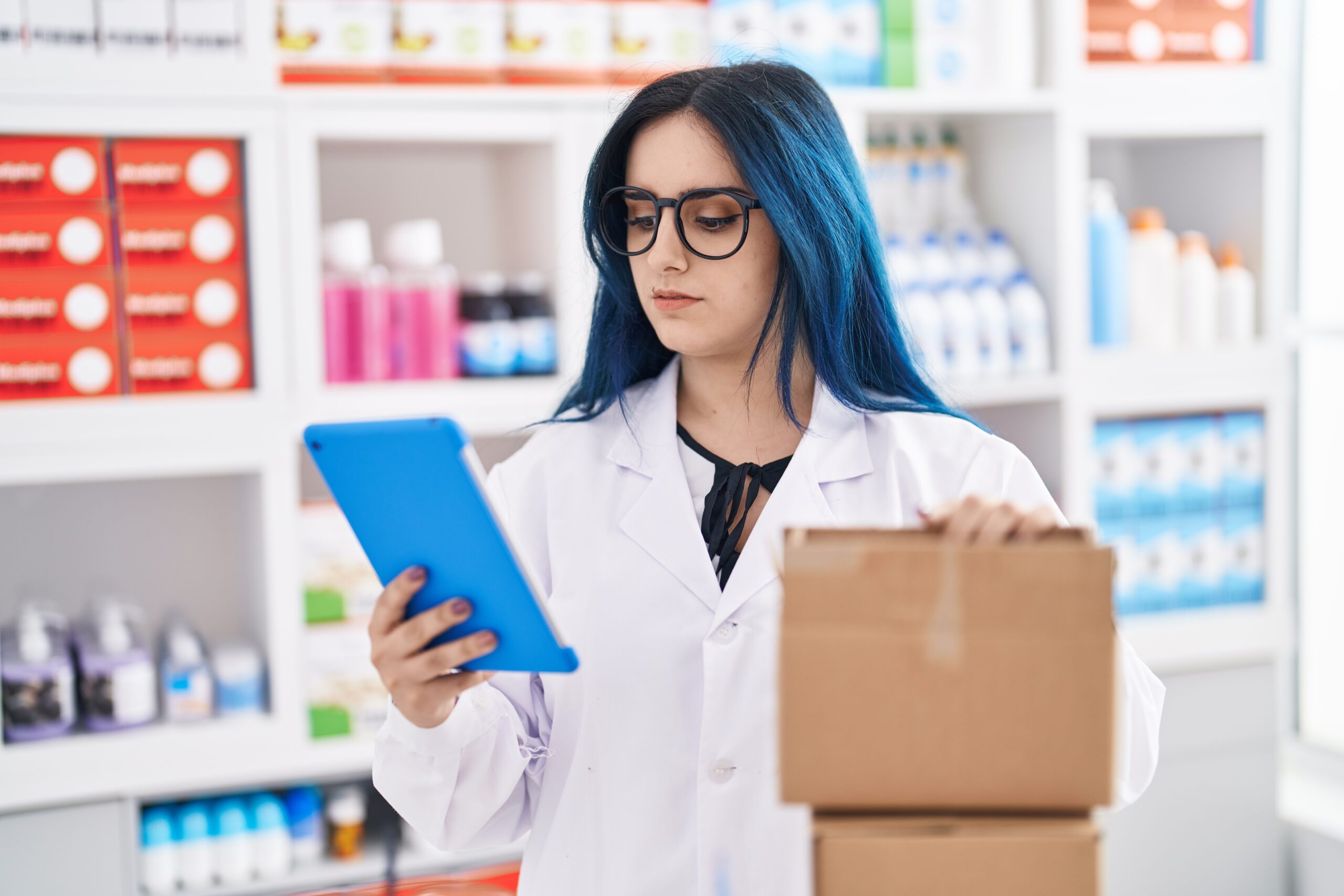 Woman pharmacist looking at tablet while preparing her expired return